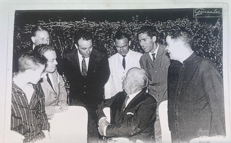 Imagen principal - 1. Francisco Franco dialoga durante la comida de recepción que dio al Batallón con los responsables de la banda, entre ellos, José Calvo, con traje gris y corbata a la derecha de la imagen. 2. Desfile por Cádiz del Batallón con José Calvo, con traje, abrigo y corbata a la izquierda de la imagen pastoreando a la banda de música. 3. El Batallón también participaba en las fiestas típicas con su chirigota.