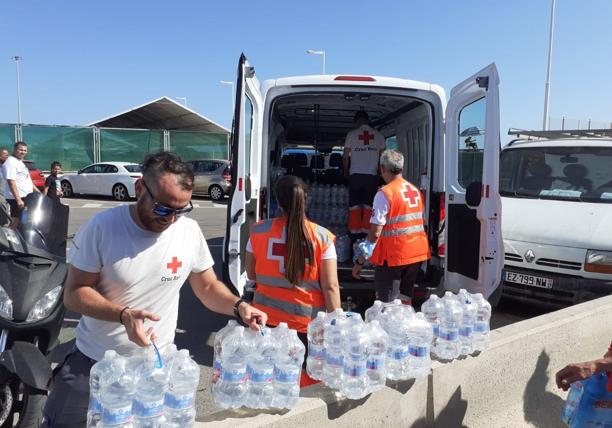Reparto de botellas de agua por los voluntarios de Cruz Roja