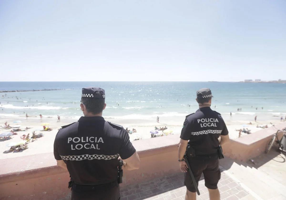 Imagen de dos poliícas locales en una plaua de Cádiz