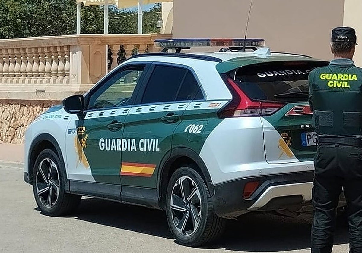 Coche y agente de la Guardia Civil, en foto de archivo.