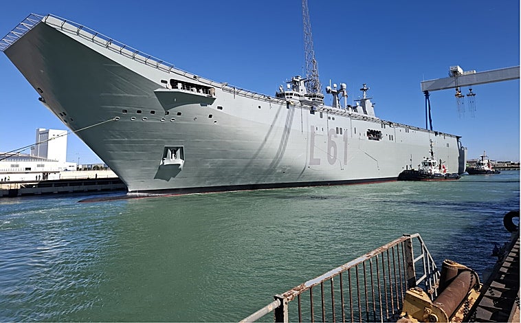 Imagen principal - Distintas imágenes del portaeronaves abandonando el dique de Puerto Real