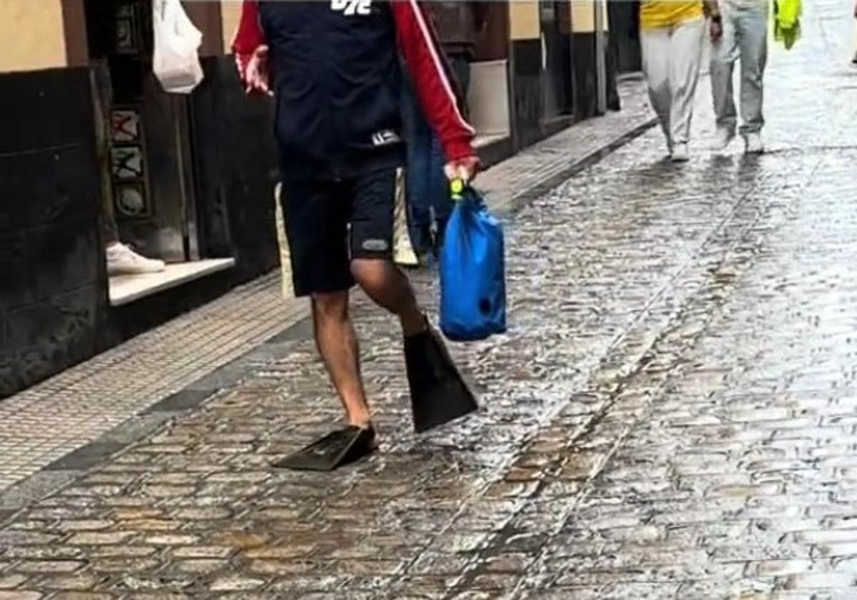 Imagen del hombre que iba caminando con aletas por Cádiz