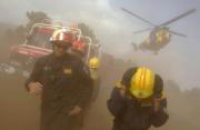 AFP  Los bomberos se protegen del polvo que levanta un helicóptero en Casavieja (Ávila)