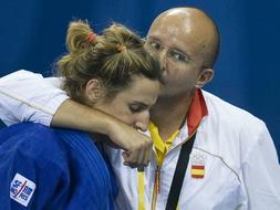 La judoca española Leire Iglesias es consolada por un integrante del equipo técnico tras ser derrotada en la lucha por el bronce. /EFE
