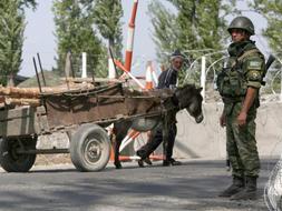 Un soldado ruso custodia un punto de control cercano a Gori, mientras un anciano georgiano lo observa. /EFE