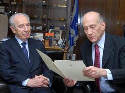 El primer ministro israelí, Ehud Olmert (derecha), le entrega la renuncia al presidente Simón Peres. /AFP