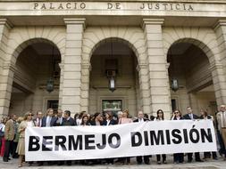 Los secretarios judiciales muestran una pancarta a las puertas de la Audiencia de Sevilla durante el paro de tres horas en protesta por la suspensión de una compañera del juzgado penal 1 de la capital hispalense./ Efe
