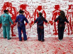 Un grupo de artistas españoles y etíopes posan delante del mural instalado en la Universidad Complutense de Madrid en el que han plasmado sus dibujos y mensajes contra la violencia machista. /Efe