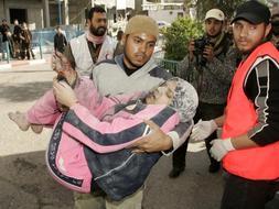 En una imagen que se repite un día tras otro, un palestino lleva a una mujer herida por las bombas israelíes al hospital. / Reuters