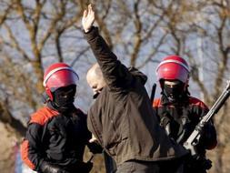 Un manifestante junto a dos agentes de la Ertzaintza durante un acto de protesta en contra del Tren de Alta Velocidad ( TAV ) convocado por AHT Gelditu, plataforma que se opone a esta infraestructura en el País Vasco./ Efe