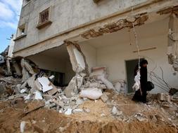 Una mujer palestina regresa a su casa destruida por los ataques isralíes en el campo de refugiados de Yabalia, en el norte de la franja de Gaza. / Efe