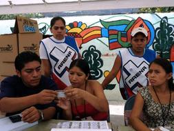 Varias personas observan las listas electorales. /Reuters