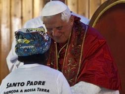El papa Benedicto XVI (d) saluda a una mujer durante el encuentro que mantuvo con fieles en la parroquia de San Antonio de Luanda, último acto de su visita a Angola ./ EFE