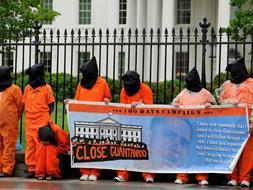 Escenificación de unos presos de Guantánamo en los 100 días de Obama como presidente ./ Reuters