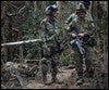 Soldados del ejército colombiano descansan cerca de un cadáver de un miembro de las FARC /en Puerto Rico, Colombia / AP PHOTO