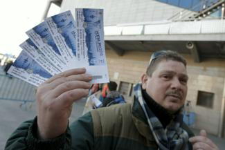 EFE | Un seguidor del Atlético enseña sus entradas para la final de la Liga Europa, el miércoles en Hamburgo