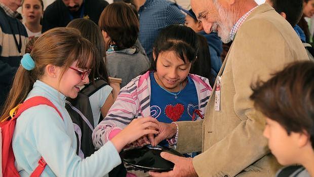 El divulgador Vicente López juega con dos niñas en el Parque de las Ciencias