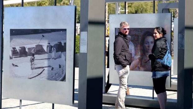 Dos personas observan una de las fotografías de la muestra / ABC