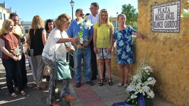 La portavoz del PP en Alcalá, Carmen Rodríguez, deja unas flores junto al nombre de Miguel Ángel Blanco