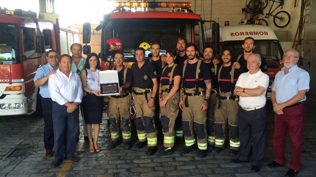 Los vecinos afectados por el fuego con los bomberos de Dos Hermanas / ABC