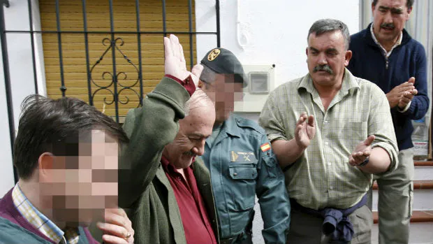 Martín Alba, tras ser detenido, saluda a los vecinos que le aplaudían