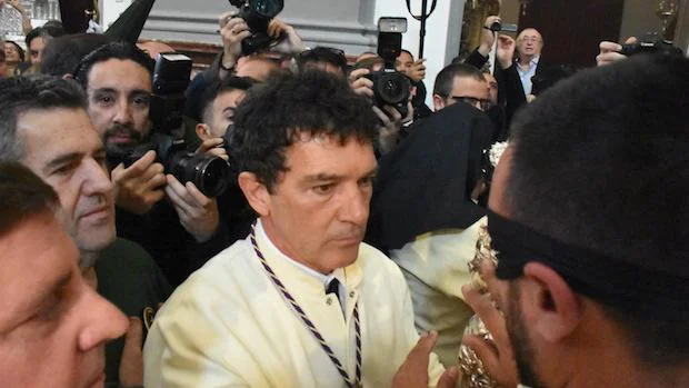 Antonio Banderas ayuda a un compañero en su promesa el Domingo de Ramos
