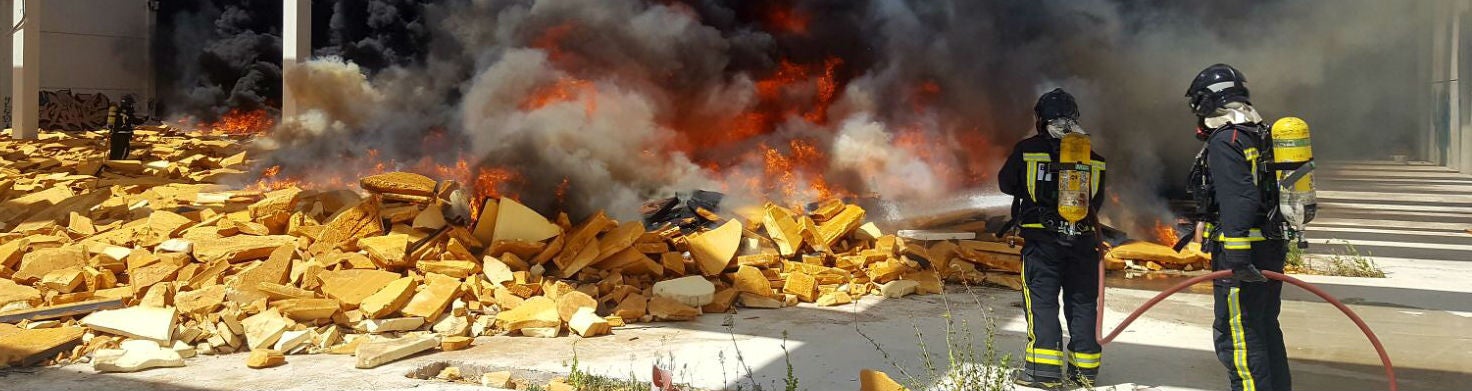 Dos bomberos sofocan las llamas de la fábrica incendiada