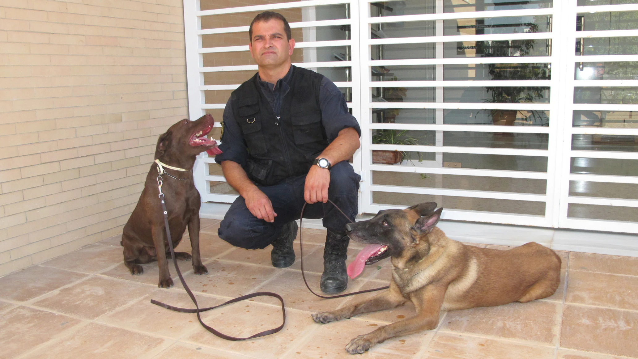 Miguel Ángel Romero con dos de los perros de la Unidad Canina de El Cuervo