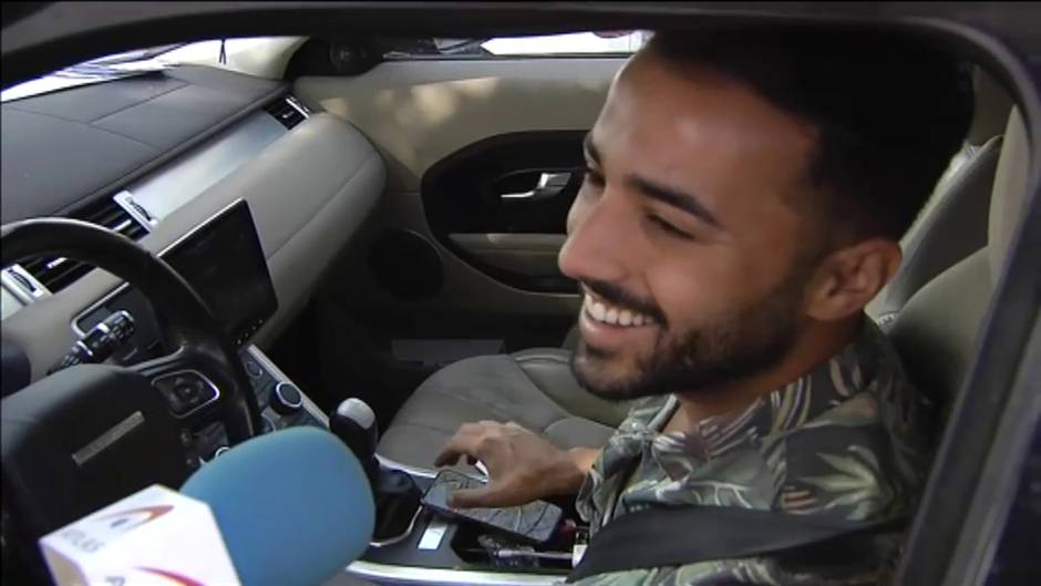 Un conductor juega con un cubo de colores mientras conduce