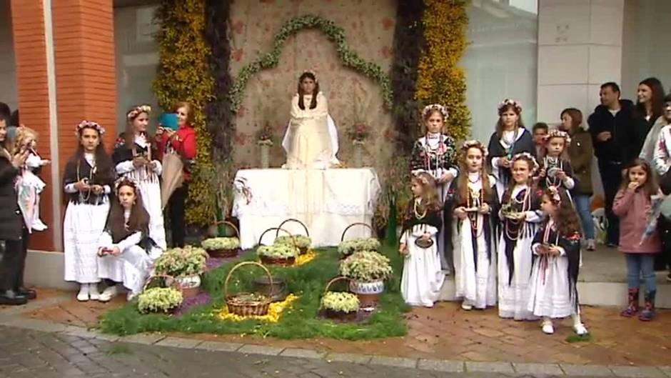 Niñas en un altar rodeadas de flores en la fiesta de La Maya de Colmenar Viejo