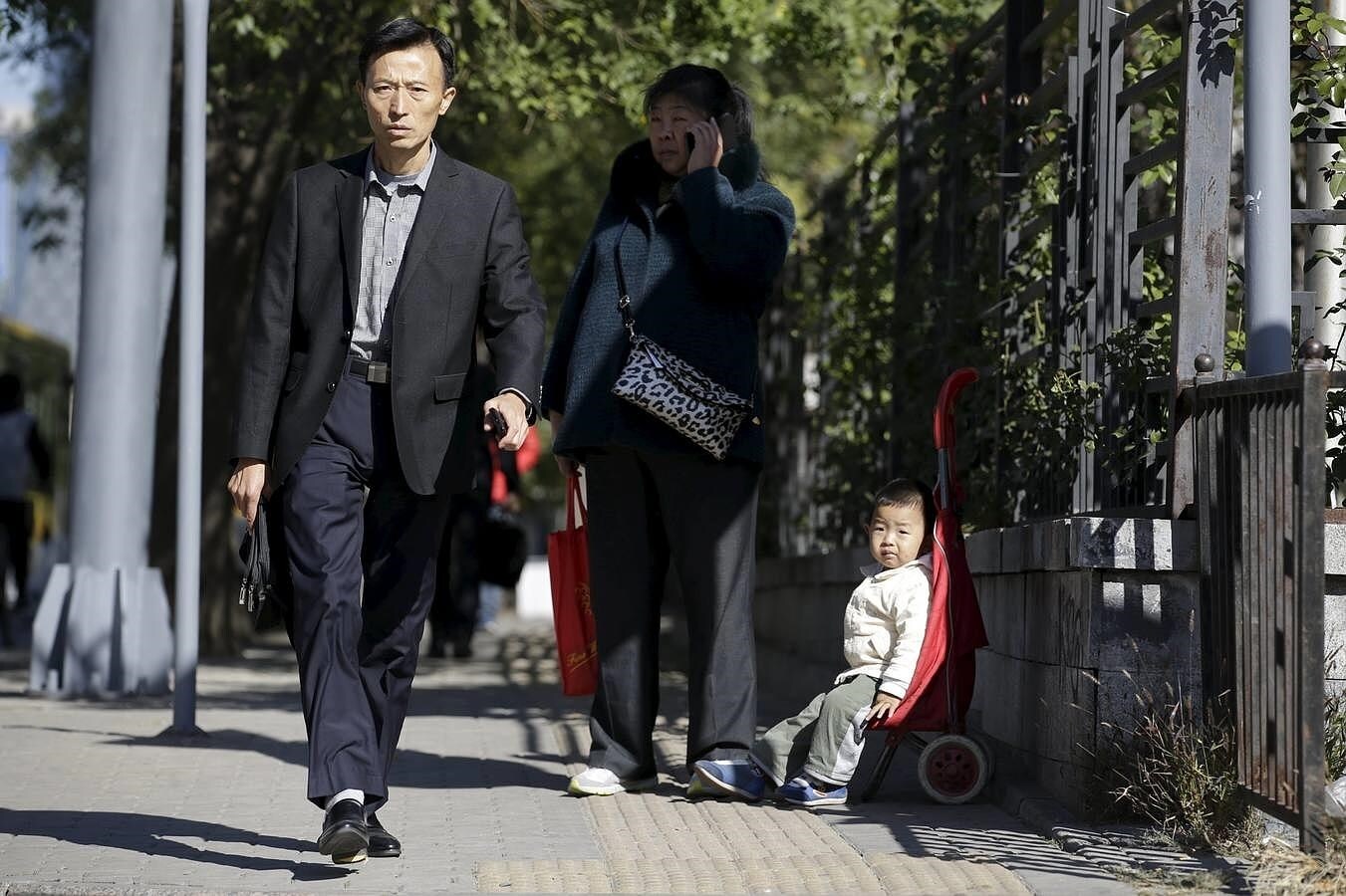 Un niño junto a su abuela en una calle de Beijing