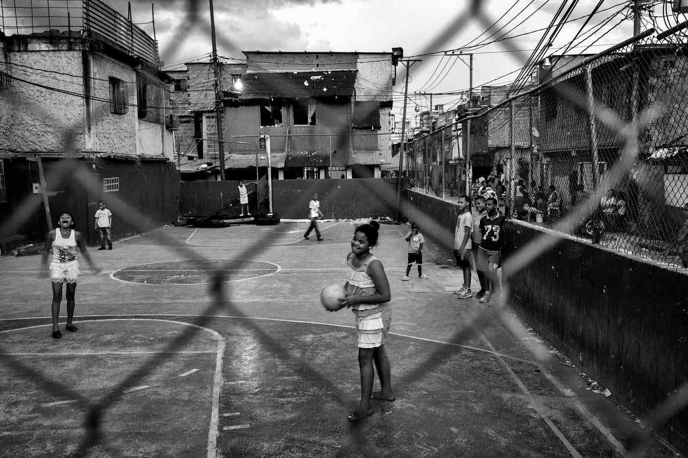 Un grupo de jóvenes juega en la cancha central de barrio de Pinto Salinas. Esta cancha de futbito y baloncesto está rodeada de varias de los principales puestos de venta de droga de la ciudad. 