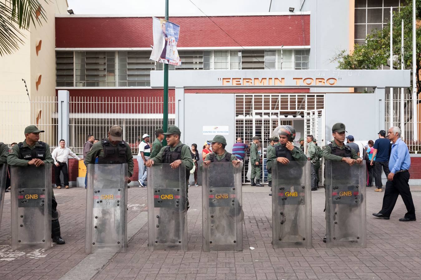 Un grupo de militares venezolanos vigila afuera de un centro de votación. 