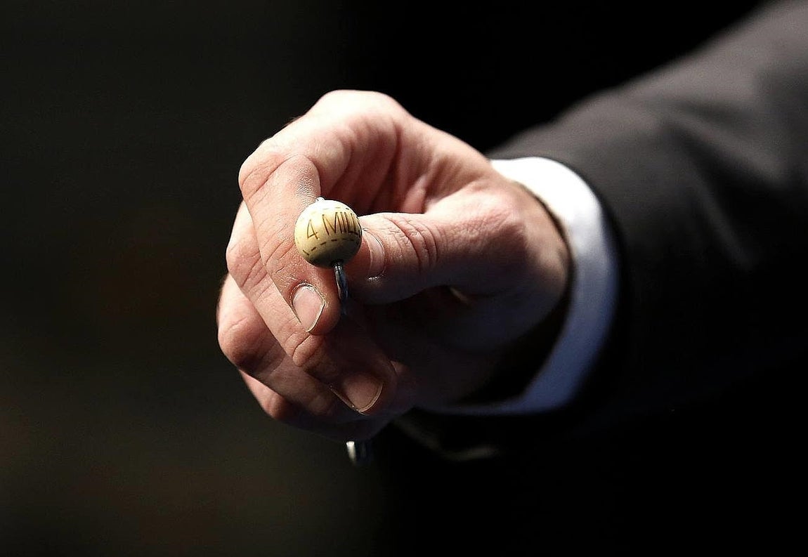 Un funcionario de Loterias y Apuestas del Estado muestra la bola con el primer premio de la Loteria de Navidad que hoy se celebra en el Teatro Real ante de introduc irla en el bombo.El Sortero de la Lotería de Navidad, el más importante, popular y longevo de los que tienen lugar en España, que reparte 2.240 millones de euros en premios, de los que 640 millones corresponderán al Gordo (400.000 euros por décimo). 