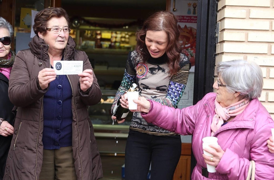 Miembros de la Cofradía del Cristo Yacente de la localidad zaragozana de Torres de Berrellén muestra una participación del número del 43.221, uno de los quintos premios del Sorteo de Navidad, comprado en una administración de Lotería de Casetas (Zaragoza). 