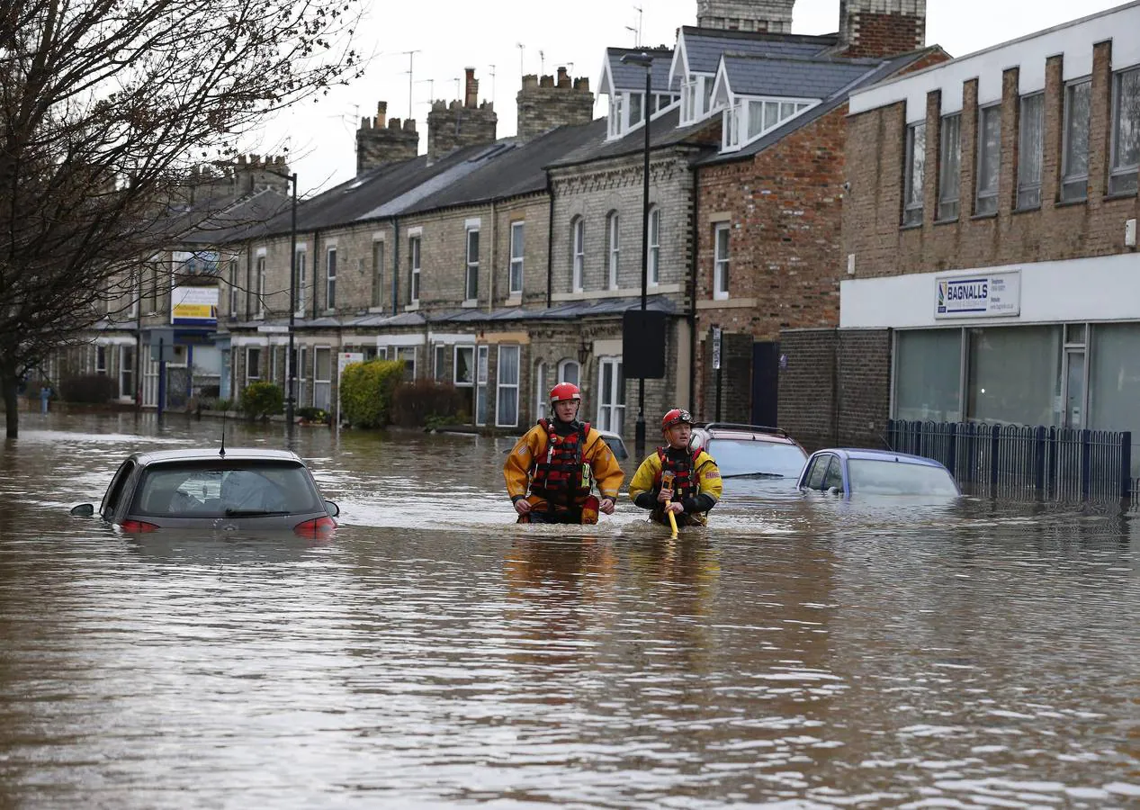 Varios miembros de los servicios de rescate evacúan a los ciudadanos de sus casas afectadas por las inundaciones en York