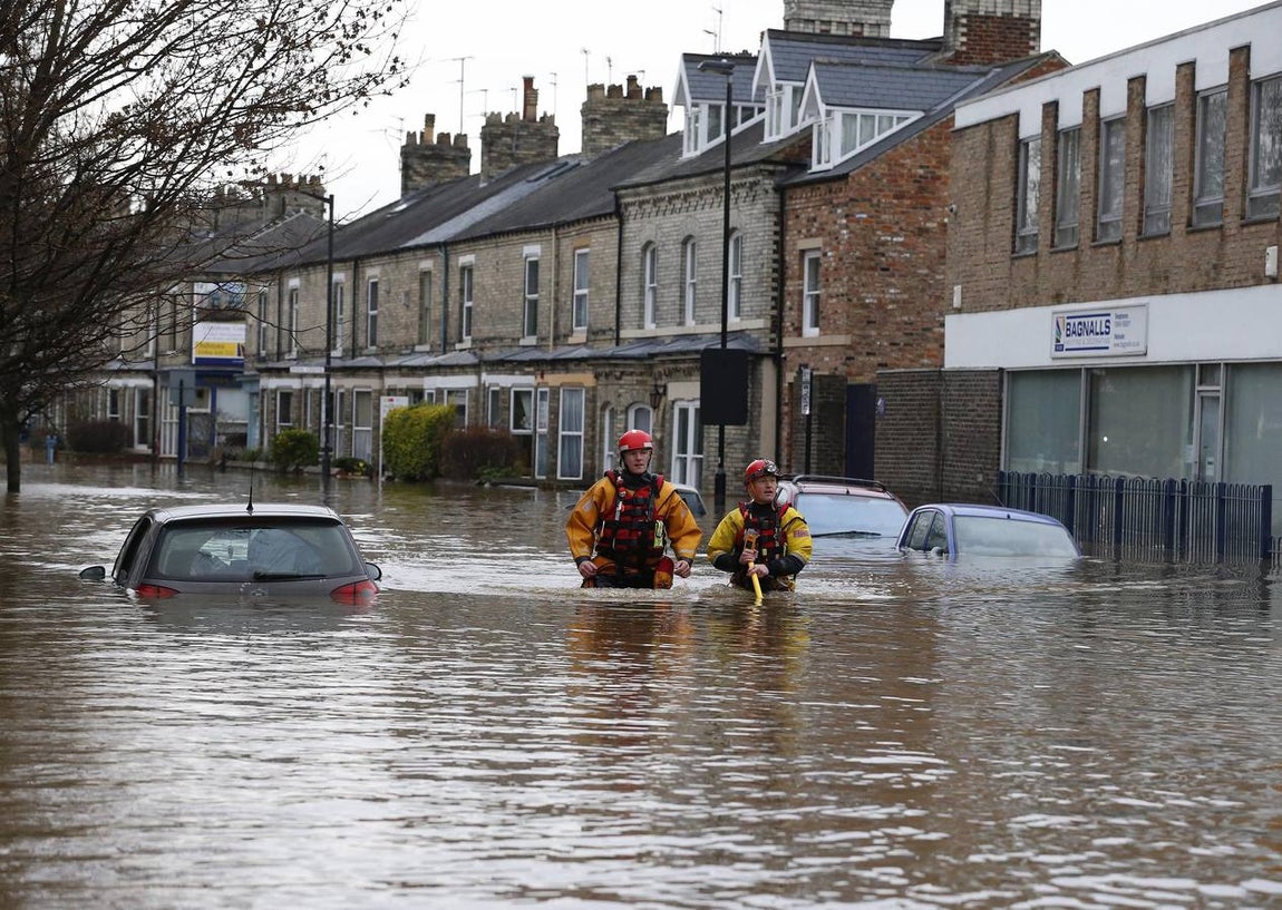 Varios miembros de los servicios de rescate evacúan a los ciudadanos de sus casas afectadas por las inundaciones en York. 