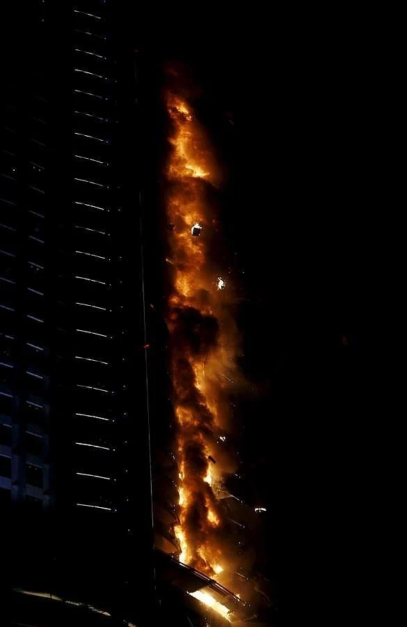 Los cascotes caen durante el incendio en el rascacielos de Dubai