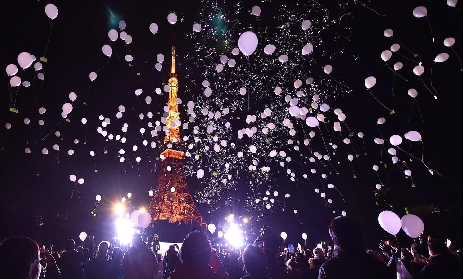 Un grupo de personas celebra el Año Nuevo con globos frente a la Torre de Tokio, en Tokio, Japón. 