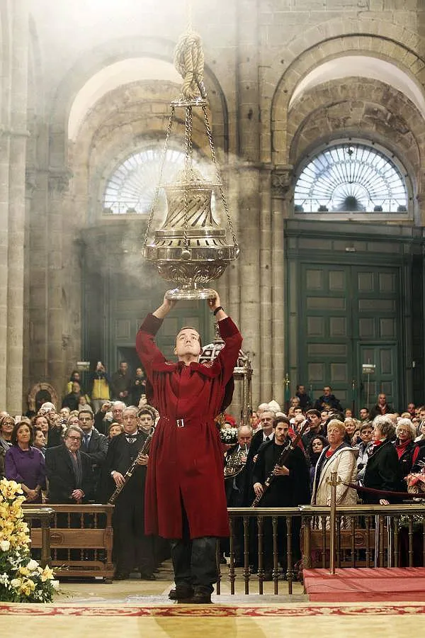 Un tiraboleiro dispuesto a lanzar el botafumeiro. Tras él, la procesión con la imagen del Apóstol Santiago