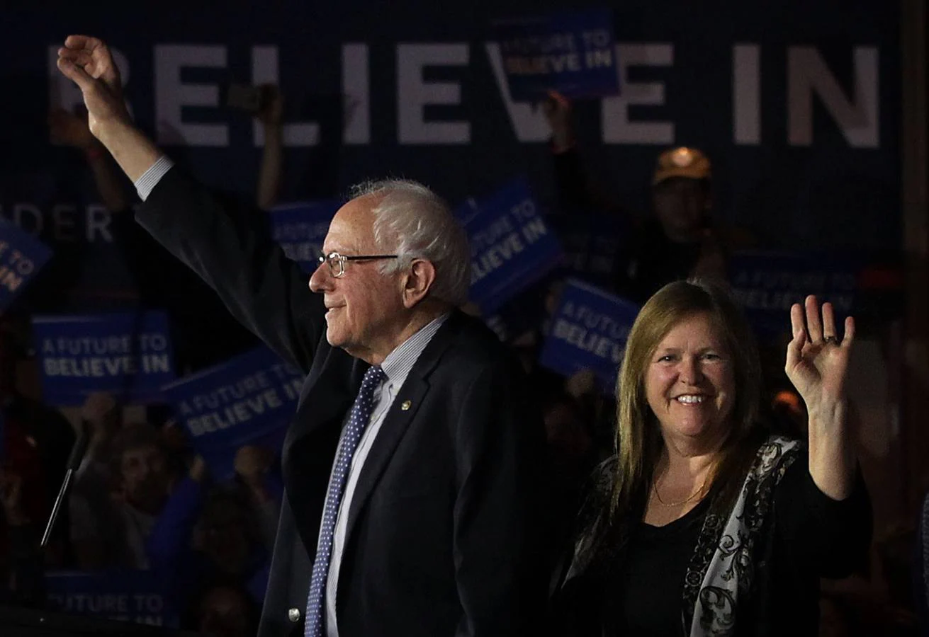 El demócrata Bernie Sanders saluda acompañado por su esposa, Jane O'Meara