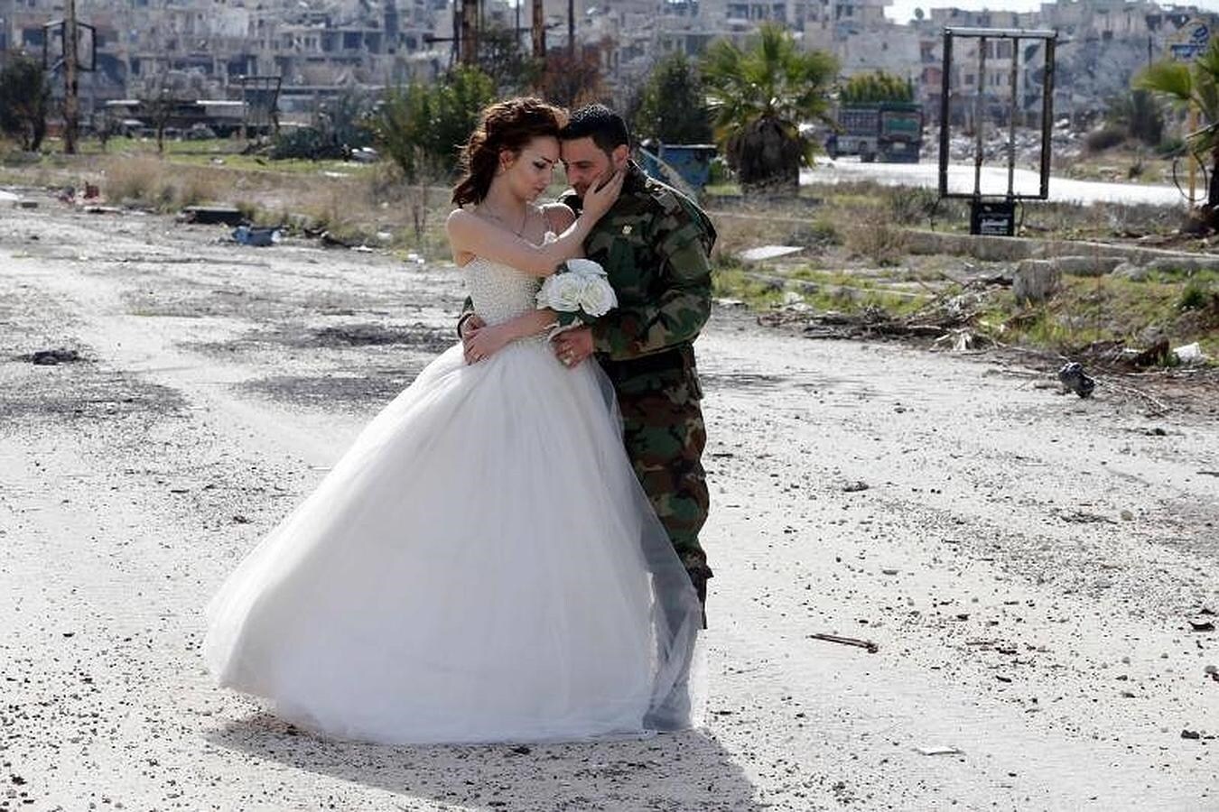 La pareja de recién casados ​​sirio se llama Nada Merhi y Hassan Youssef, que posa con un traje camuflaje sirio