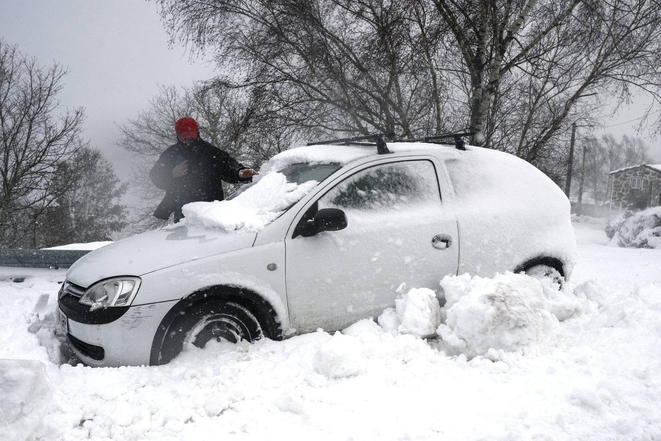 Un hombre limpia su coche cubierto de nieve en el municipio orensano de Chandrexa de Queixa. 