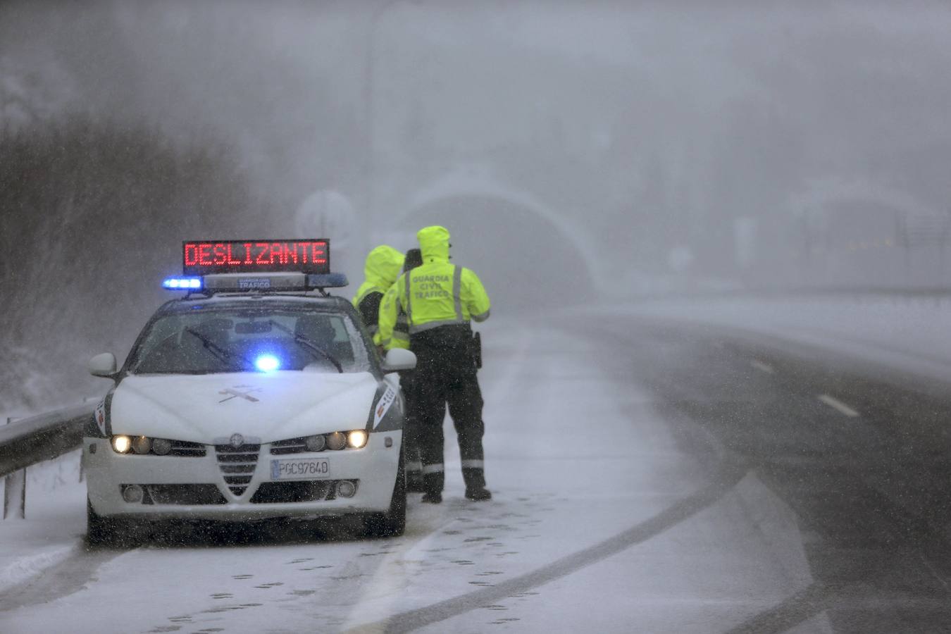 Una patrulla de la Guardia Civil en las inmediaciones del puerto de A Canda, en una jornada en la que la nieve y el viento complican la circulación entre Galicia y la Meseta. 