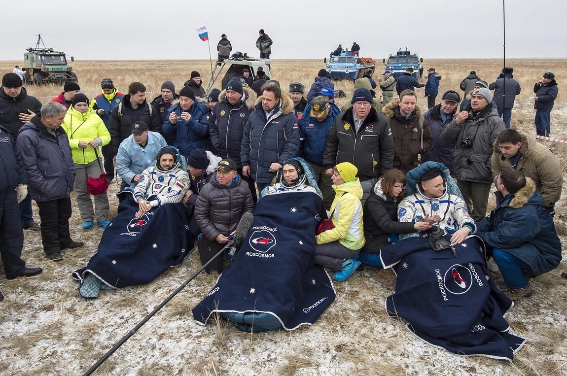 Los cosmonautas rusos de Roscosmos Mikhail Kornienko (izda) y Sergey Volkov (centro) y el comandante de la expedición 46 en la ISS, Scott Kelly, de la NASA (dcha.), descansan en sillas después del aterrizaje. 