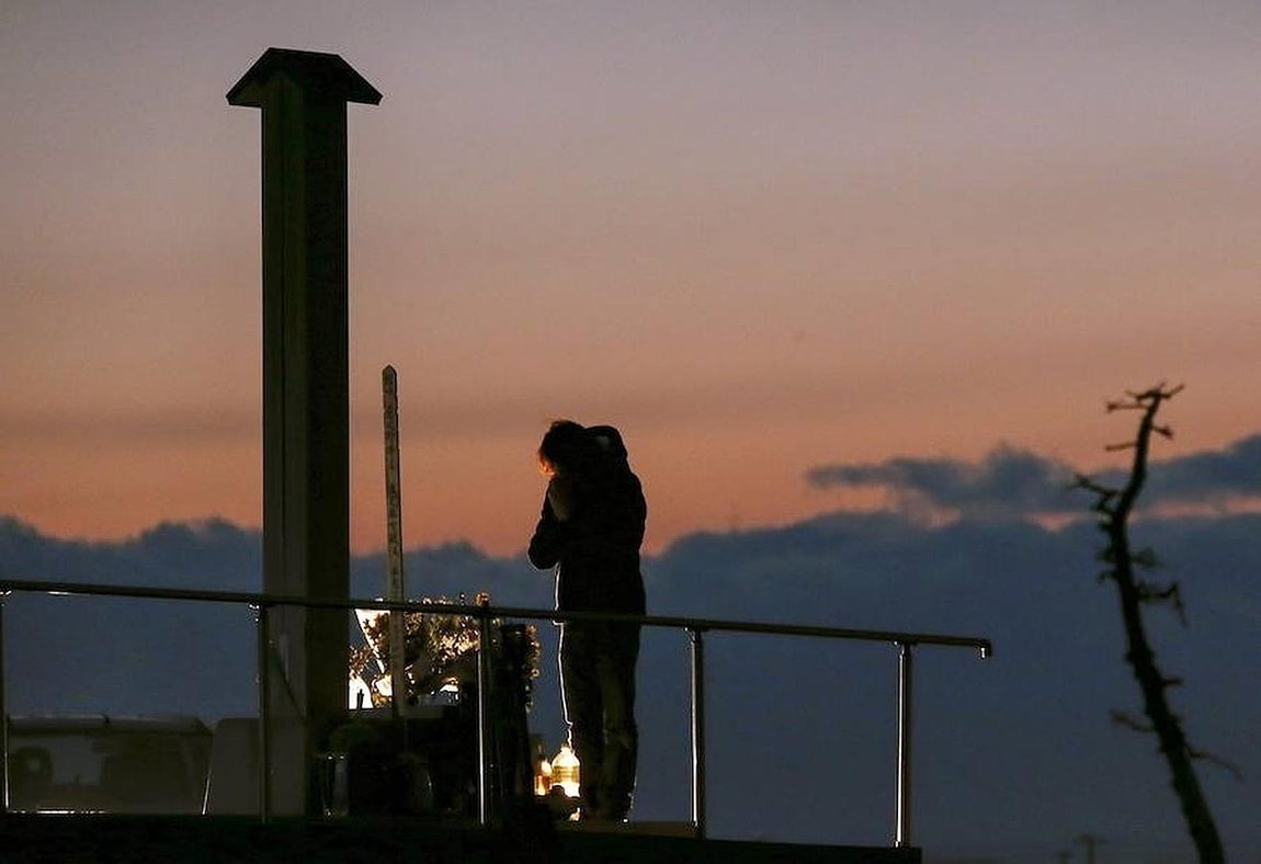 Una mujer reza junto a un monumento en memoria de las vícitmas, en la devastada localidad de Arahama, en el distrito costero de Sendai, este jueves. 