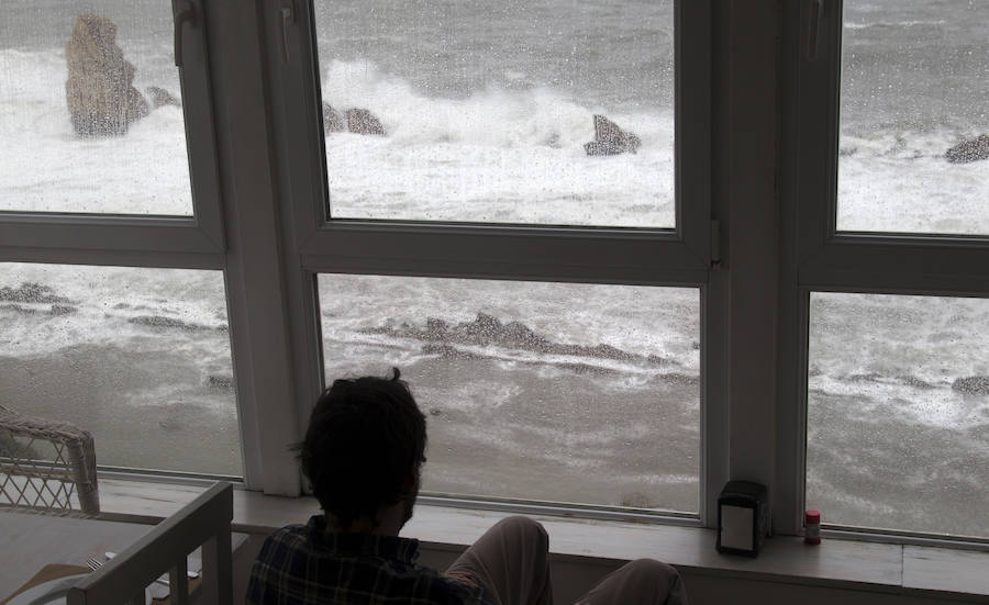 Un chico observa el oleaje en la costa de la playa de La Arnia. 