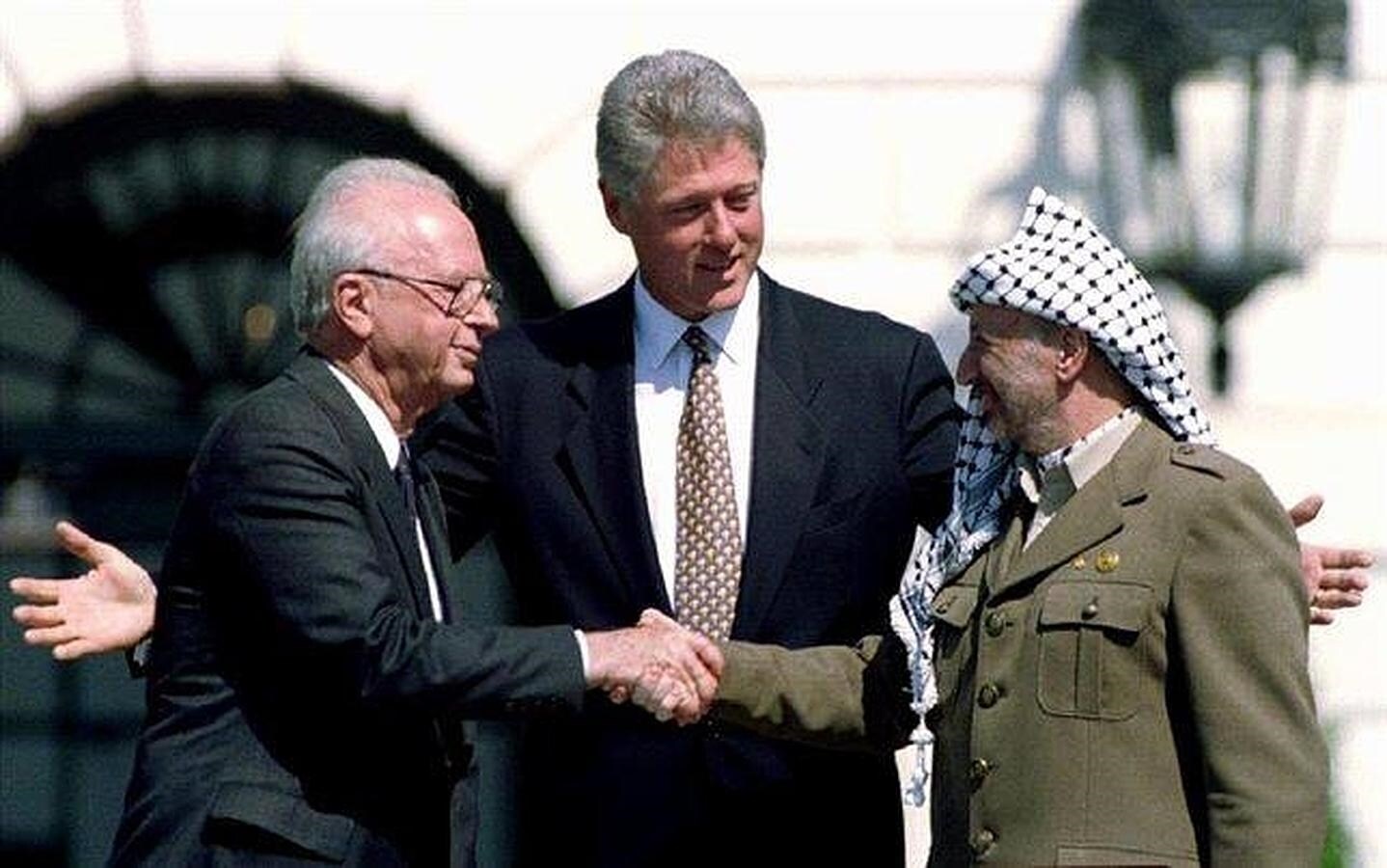Simbólico apretón entre el histórico líder palestino Yasir Arafat y el primer ministro israelí, Isaac Rabin, tras la firma de un acuerdo de paz auspiciado por Clinton, el 13 de septiembre de 1993