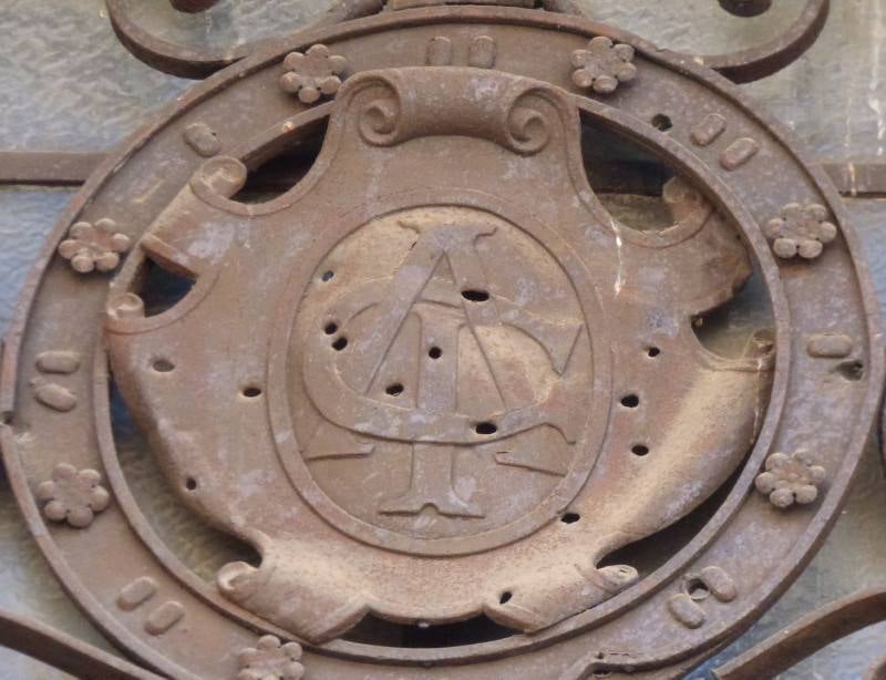 Medallón balaceado con las iniciales CAI en la puerta principal. 