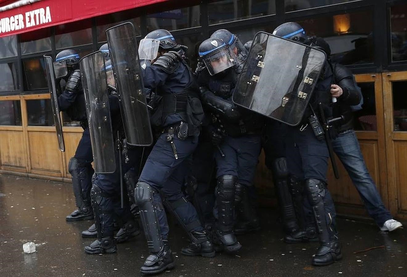 Un grupo de policías se protegen con los escudos durante una de las manifestaciones que están teniendo lugar en París este jueves. 